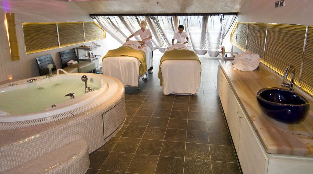 Massage therapists administer a couple's bamboo massage on Carnival Magic's Cloud 9 Spa. The two-level facility also includes a full gymnasium, thermal suite and spa accommodations with special access and privileges. Photo by Andy Newman/Carnival Cruise Lines