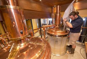 Carnival Vista Brewmaster Colin Presby pours malt into a mash tun located in the RedFrog Pub's brewery house onboard the Carnival Vista. The largest and most innovative cruise vessel in Carnival Cruise Line's fleet, Carnival Vista measures 133,500 tons, 1,055 feet long and has a guest capacity of almost 4,000 passengers. Photo by Andy Newman/Carnival Cruise Line