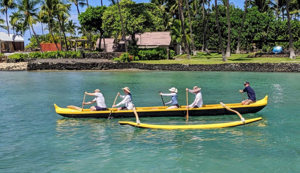 paddling a traditional wooden canoe in Kona