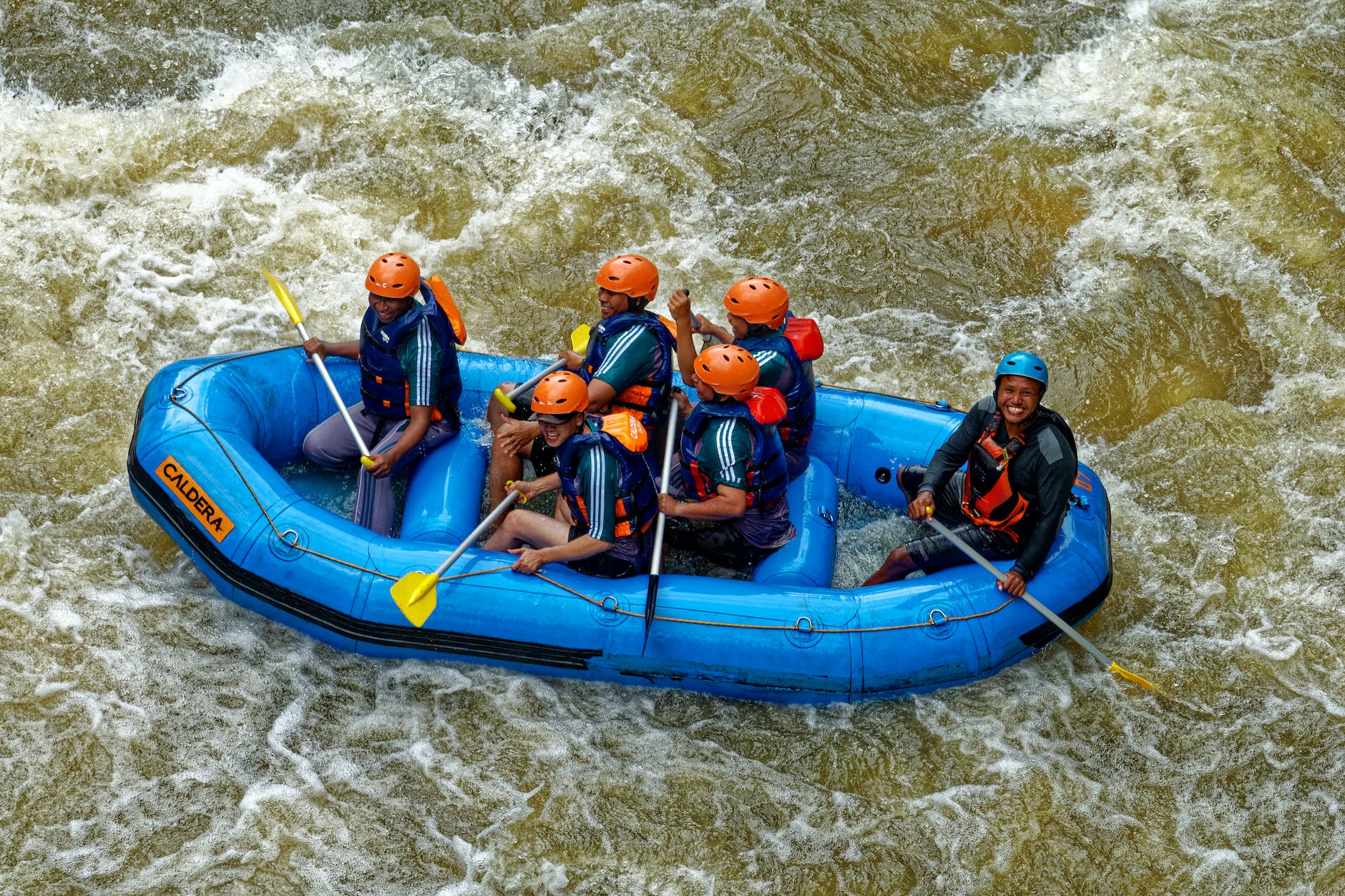 group of people riding blue raft on body of water
