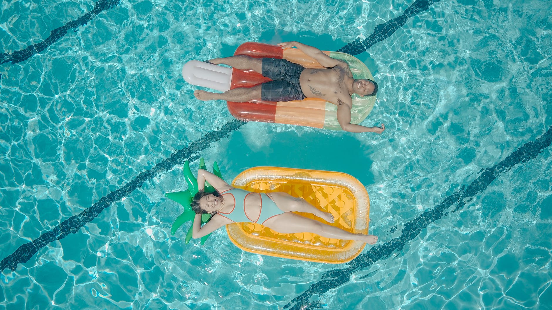 man and woman swimming in the pool